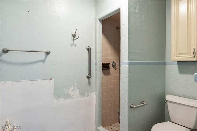 bathroom featuring tiled shower, tile walls, and toilet