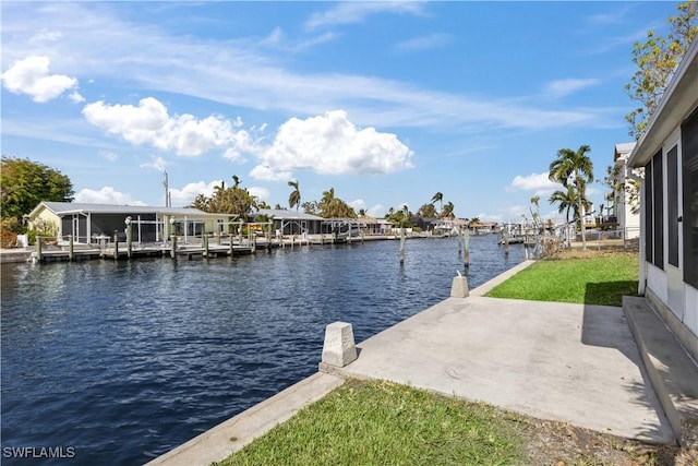 view of dock featuring a lawn and a water view