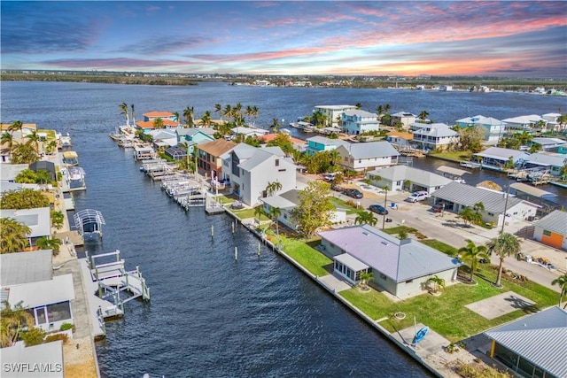 aerial view at dusk featuring a water view