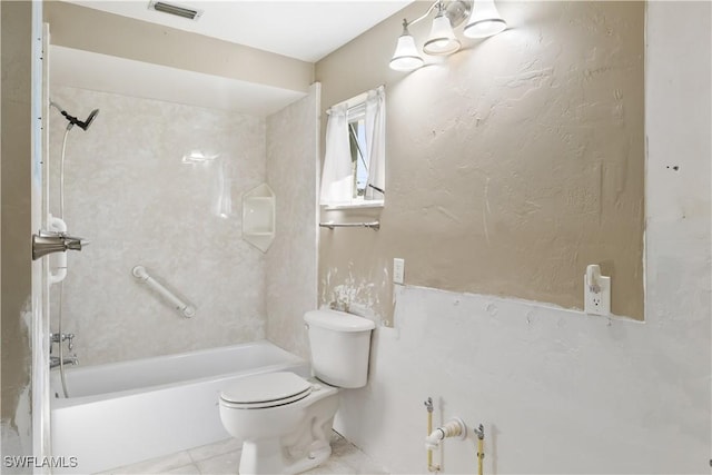 bathroom featuring tiled shower / bath combo and toilet