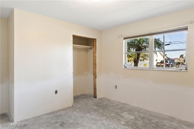 unfurnished bedroom featuring a closet and concrete floors