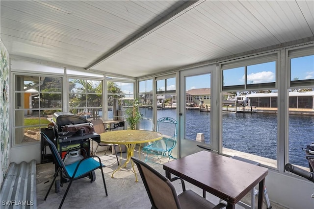 sunroom / solarium featuring a water view