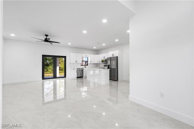 unfurnished living room featuring french doors and ceiling fan