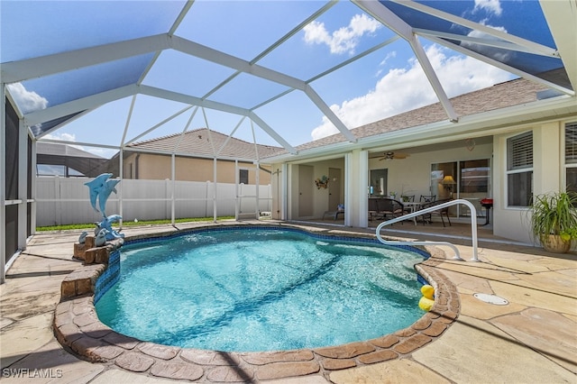 view of pool with a patio, glass enclosure, and ceiling fan