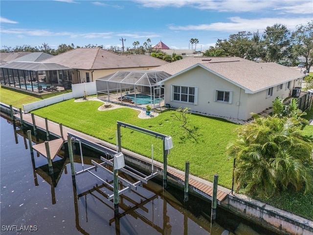 view of dock with a patio, a lawn, and glass enclosure