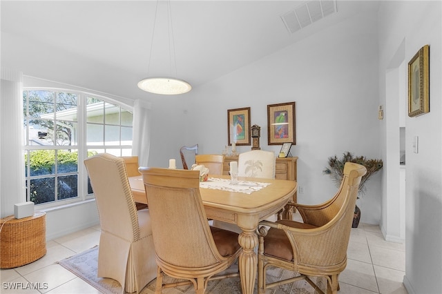 dining room featuring light tile patterned floors and vaulted ceiling