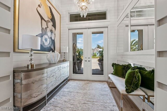 entryway with french doors, a notable chandelier, and hardwood / wood-style floors