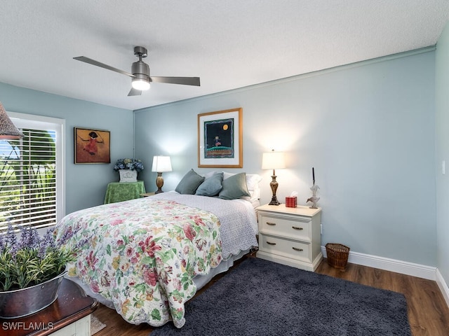 bedroom featuring dark hardwood / wood-style flooring, a textured ceiling, and ceiling fan