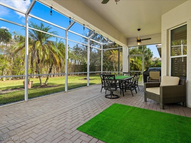 unfurnished sunroom with ceiling fan