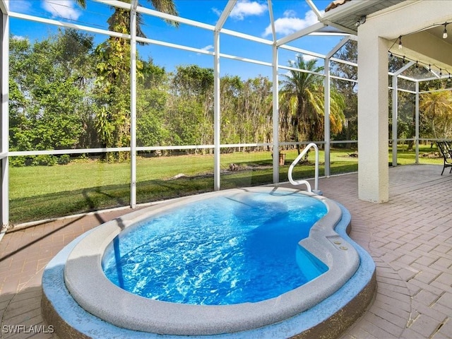 view of swimming pool featuring a yard, a patio area, and a lanai