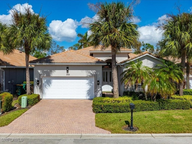 mediterranean / spanish-style home featuring a garage and a front yard