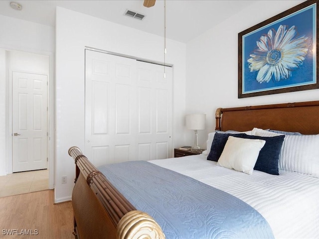 bedroom featuring ceiling fan, light wood-type flooring, and a closet