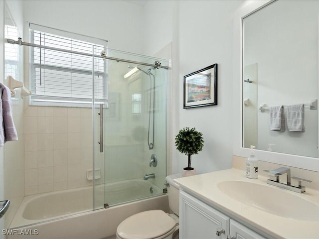 full bathroom featuring shower / bath combination with glass door, vanity, and toilet