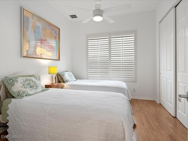 bedroom featuring ceiling fan, a closet, and light wood-type flooring