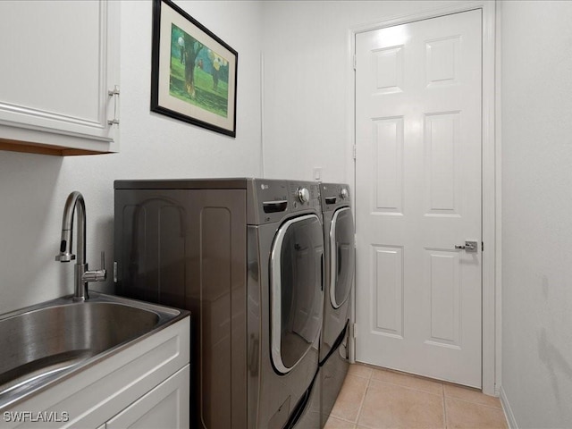 laundry area with cabinets, light tile patterned floors, separate washer and dryer, and sink