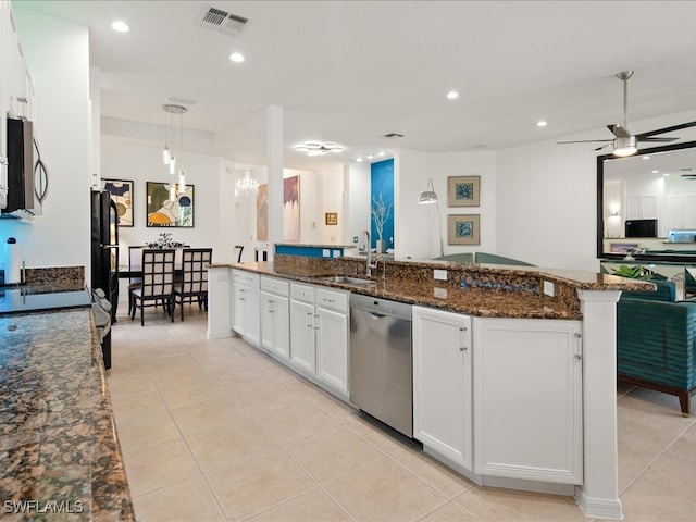 kitchen with white cabinetry, sink, hanging light fixtures, stainless steel appliances, and dark stone counters