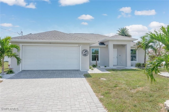 view of front of house with decorative driveway, roof with shingles, stucco siding, a garage, and a front lawn