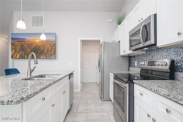 kitchen featuring sink, hanging light fixtures, light stone counters, white cabinets, and appliances with stainless steel finishes