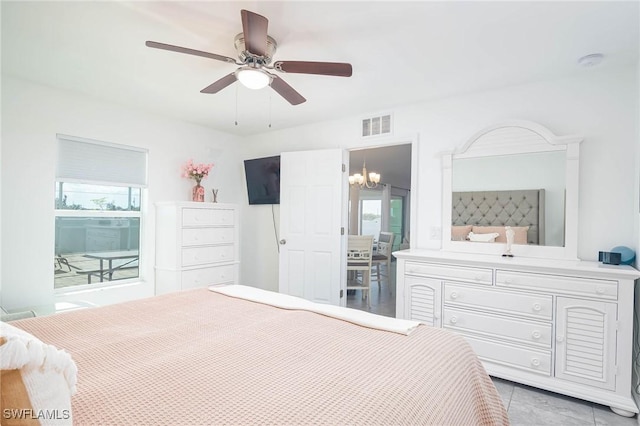 tiled bedroom featuring ceiling fan with notable chandelier