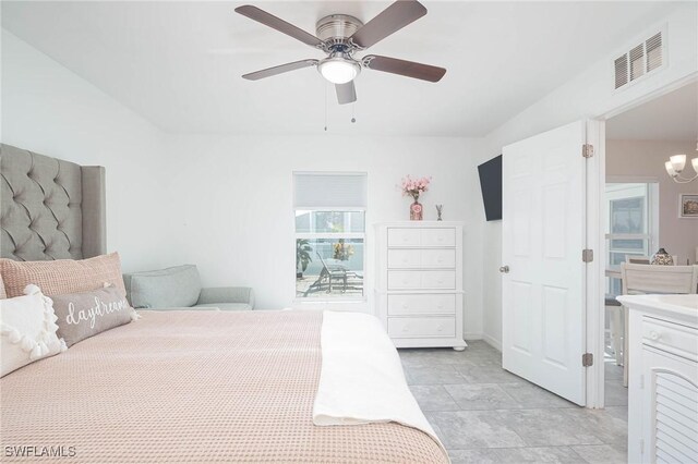 bedroom featuring ceiling fan with notable chandelier