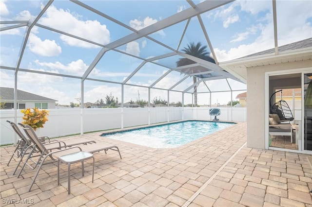 view of swimming pool with glass enclosure and a patio area