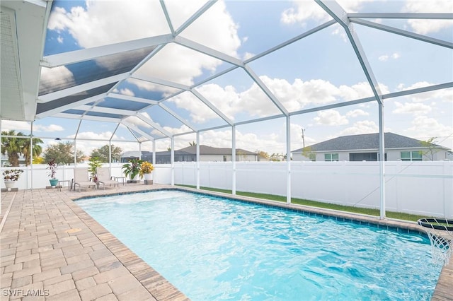 view of swimming pool featuring glass enclosure and a patio area