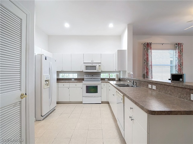 kitchen with kitchen peninsula, white cabinets, sink, and white appliances