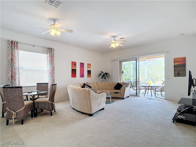 carpeted living room with ceiling fan