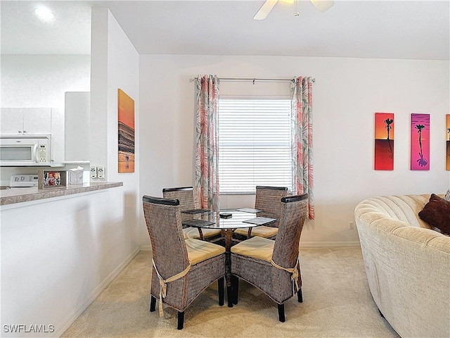 dining area featuring light colored carpet and ceiling fan