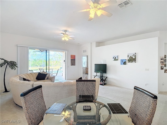 carpeted living room featuring ceiling fan and a fireplace