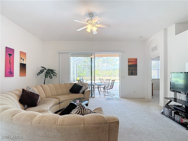 carpeted living room with ceiling fan