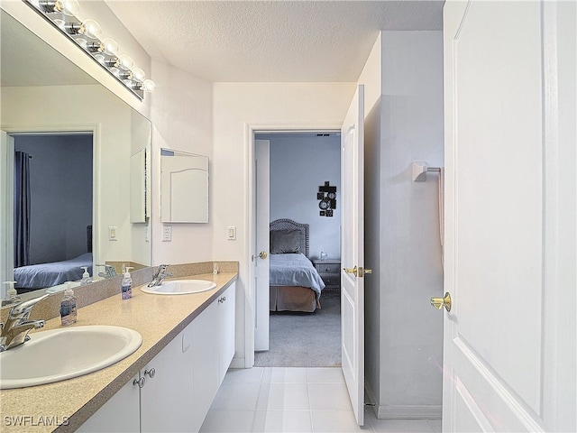 bathroom with vanity, a textured ceiling, and tile patterned flooring