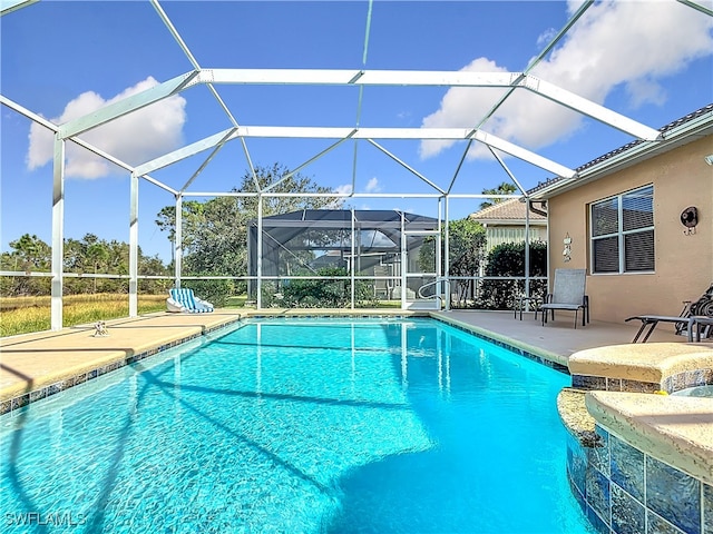 view of pool with a patio area and glass enclosure