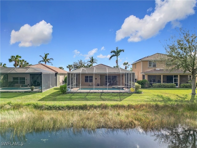 rear view of property with a lawn, a water view, and glass enclosure