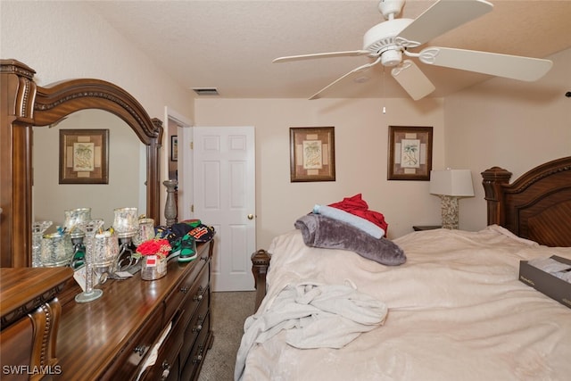 carpeted bedroom with a textured ceiling and ceiling fan