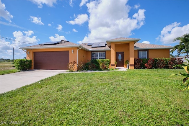 view of front of property featuring solar panels, a front yard, and a garage