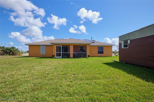 back of property with a yard and a sunroom