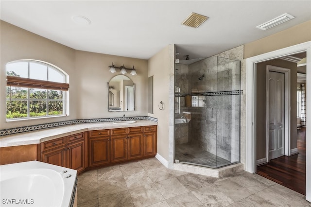 bathroom featuring vanity, independent shower and bath, and hardwood / wood-style floors