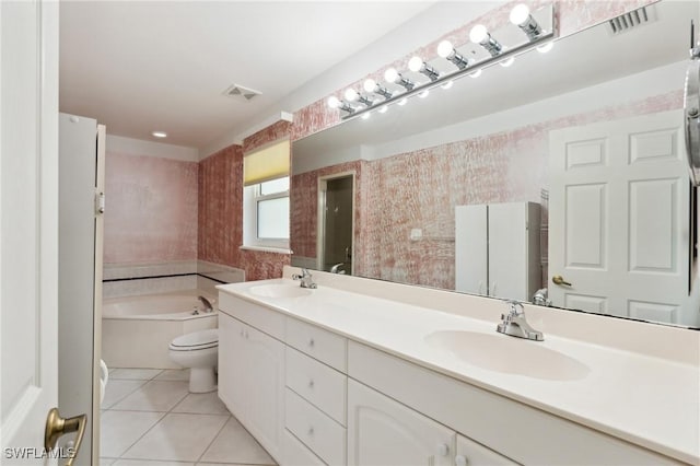 bathroom featuring tile patterned floors, a bathing tub, vanity, and toilet