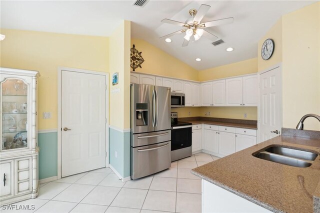 kitchen featuring stainless steel appliances, vaulted ceiling, ceiling fan, sink, and white cabinets