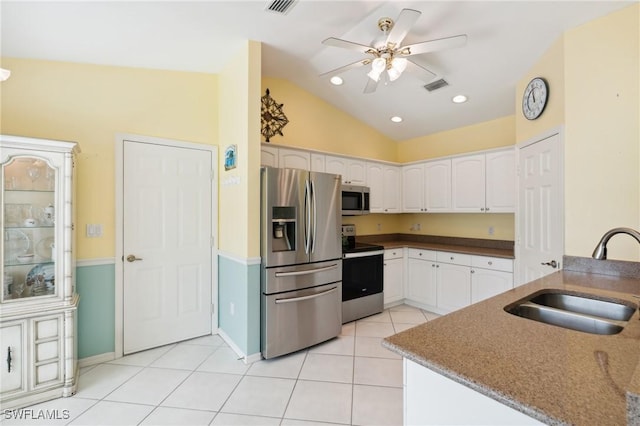 kitchen with lofted ceiling, stainless steel appliances, sink, white cabinets, and light tile patterned flooring