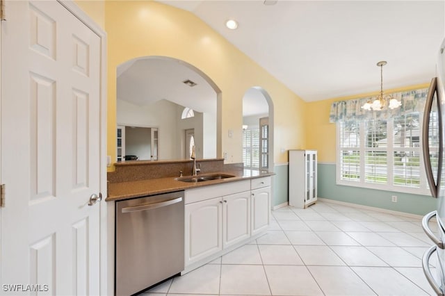 kitchen featuring lofted ceiling, sink, decorative light fixtures, stainless steel appliances, and white cabinets