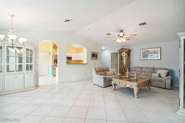 tiled living room with lofted ceiling and ceiling fan with notable chandelier