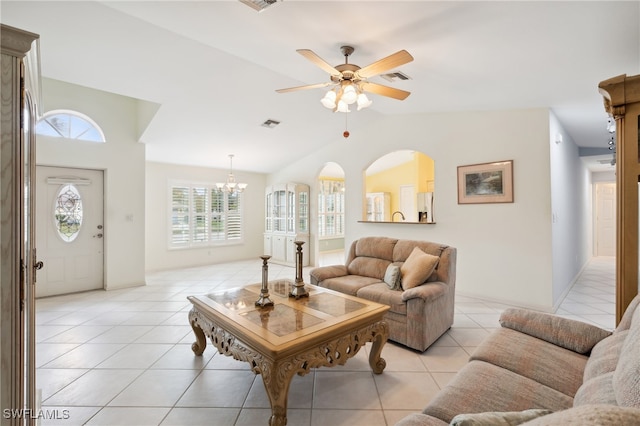 living room with ceiling fan with notable chandelier, light tile patterned floors, and vaulted ceiling