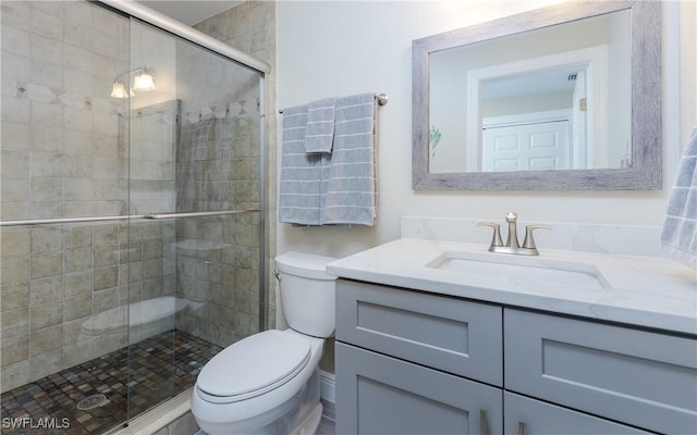 bathroom with vanity, toilet, and a shower with shower door