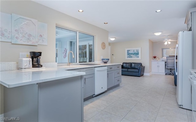 kitchen with gray cabinetry, ceiling fan, kitchen peninsula, and white appliances