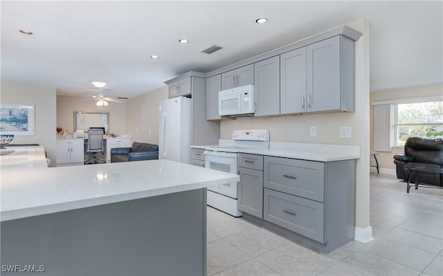 kitchen featuring light tile patterned floors, white appliances, gray cabinets, and ceiling fan