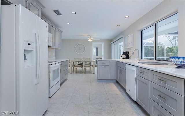 kitchen with gray cabinetry, ceiling fan, sink, and white appliances