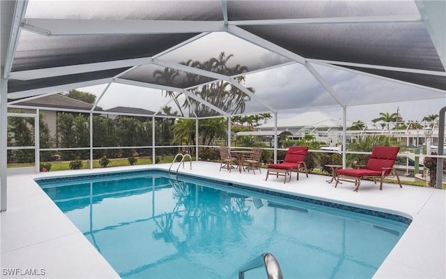 view of swimming pool with glass enclosure and a patio area