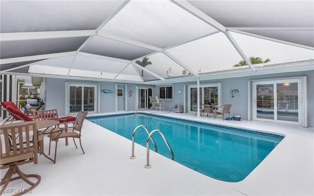 view of swimming pool featuring a lanai and a patio